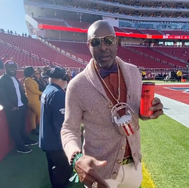 Jerry Rice is wearing a big, shiny GOAT 49ers helmet chain