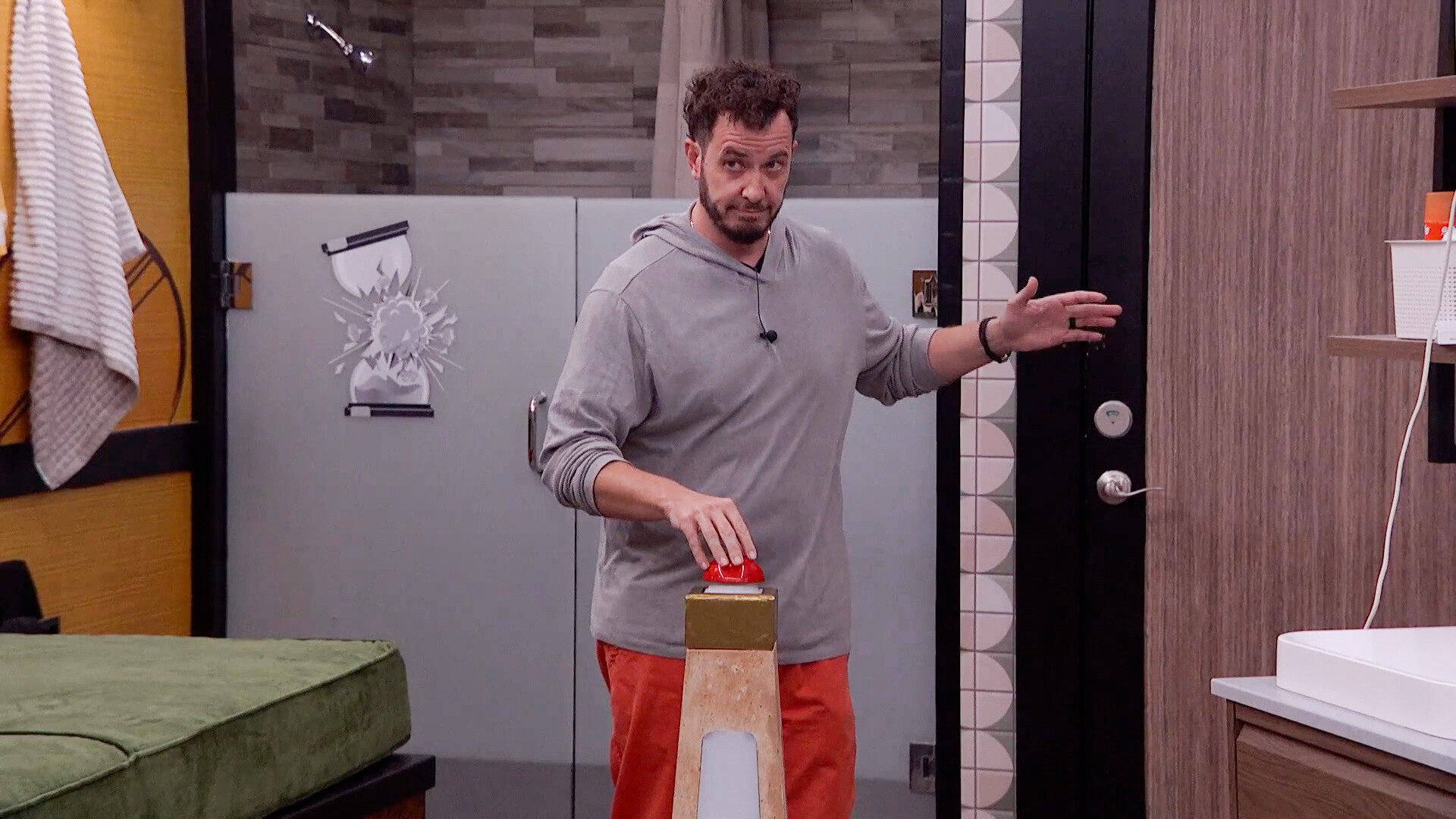 Rick Devens pressing a red button in the Big Brother house